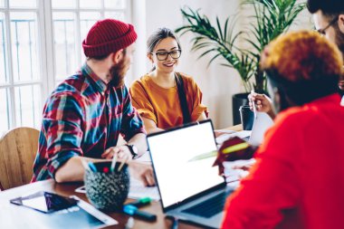 Tartışmak için toplantısı gülümseyen kadın meslektaşı konuşurken genç erkek çalışan projeler, samimi atmosferinde işbirliği tasarımcıları olumlu mürettebatı, öğrenciler üzerinde teamworkin eğlenceler