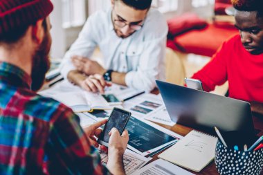 Bilgi teknolojisi ve wifi, smartphone multimedya dosya Paylaş holding adam kullanarak ağ arama üzerinde çok ırklı meslektaşlarının kırpılmış görüntü konsantre