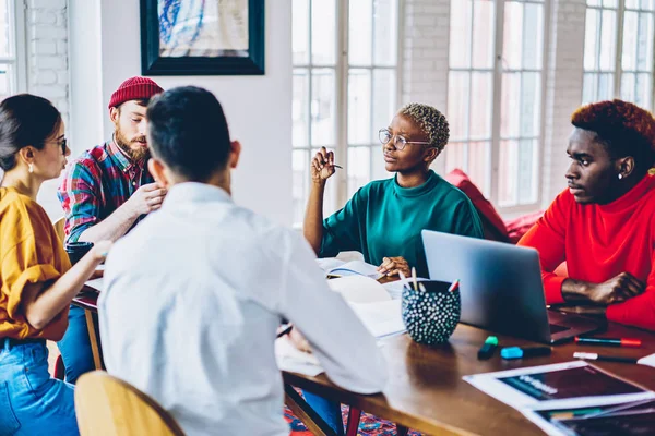 Jóvenes Colegas Multirraciales Hablando Entre Sentados Escritorio Con Computadoras Portátiles — Foto de Stock