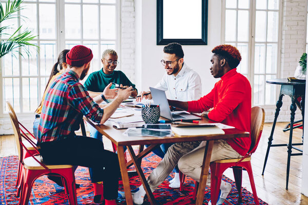 Multiracial crew of employees suggesting their ideas to female leader during meeting table, male and female coworkers having productive working process in collaboration,students enjoying worksho