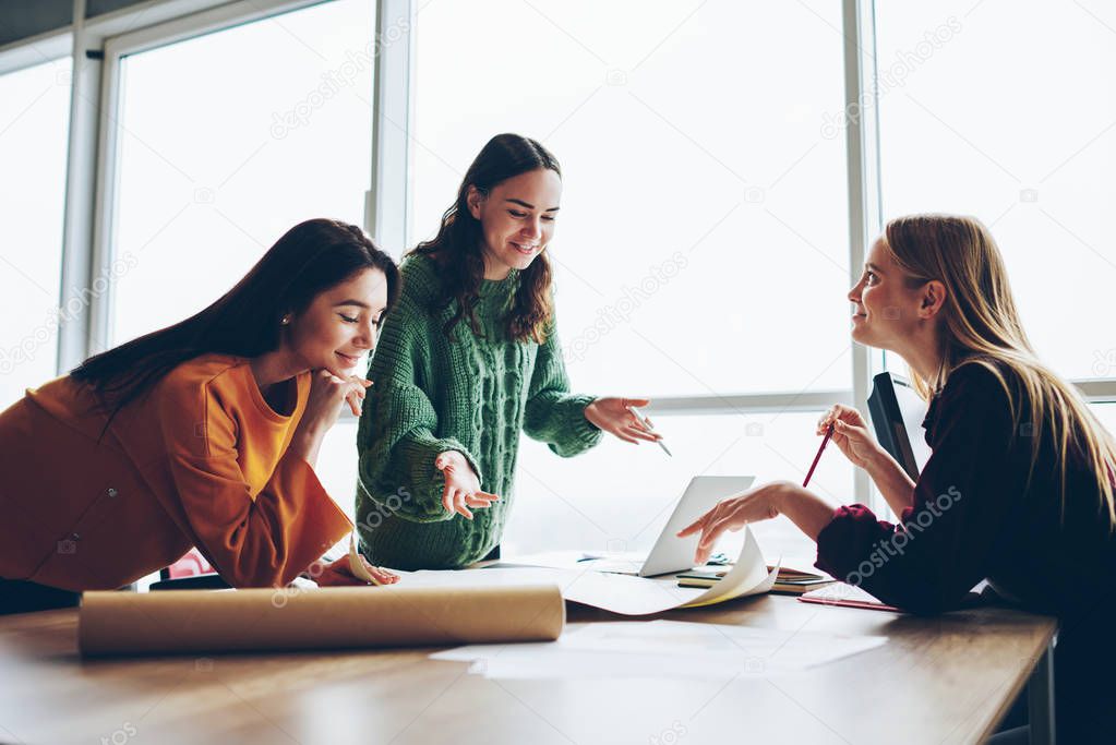 Positive female colleagues checking graphic planning on desktop satisfied with accountings and design,skilled women crew creating sketch for architecture cooperating and brainstorming in good mood