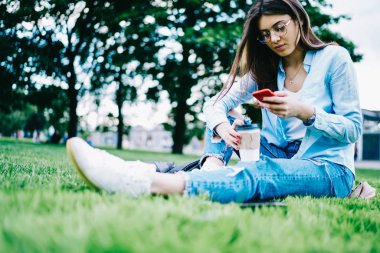 Dalgın genç kadın 4 g internet harcama kahve molası Park bağlı Smartphone cep telefonu ile kontrol bildirim, Genç kadın blogger güncelleştirmek onun profil cep telefonu serbest zaman açık havada harcama üzerinden