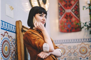 Çekici hippi kız olumlu arama arkadaşıyla yeni uygulama üzerinden cep telefonu, kablosuz 4 g kullanan kadın çekici genç muhabbet için smartphone aygıt ile iletişim internet