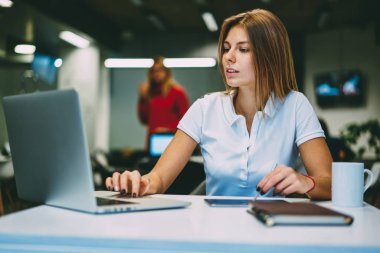 Sarışın genç kadın, serbest meslek sahibi metin modern dizüstü bilgisayar klavyede yazarak Internet sitelerinde bilgi arama. Hipster öğrenci ders çalışma alanı coworking içinde netbook, üzerinde çalışma