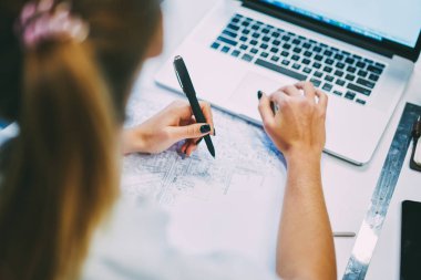 Vasıl okul sırası blueprint ve modern dizüstü bilgisayar kablosuz internet kullanarak bina ile oturan genç kadın arkadan görünüm kırpılmış. Dijital netbook aygıt arama bilgi üzerinde USB'yi öğrenci