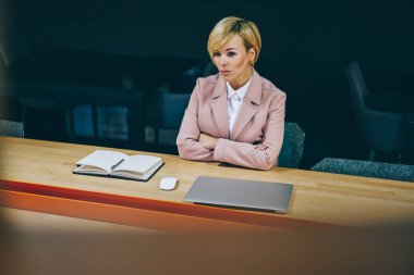Çapraz elle doğrudan ders sırasında sınıfa arıyorum ciddi deneyimli kadın profesörü. Akıllı kadın girişimci 50 yaşında oturma ahşap masada dizüstü bilgisayar ve Not defteri ile