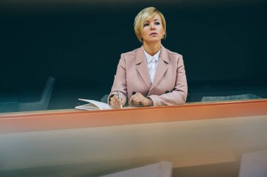 Olgun kadın girişimci iş belgeleri çalışma şık ceket giymiş. Ciddi akıllı Profesör 50 yaşında ders Üniversitesi'nde yürütülmesi sırasında Notlar Not Defteri'nde yapma