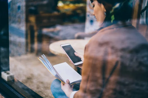 千禧时髦女孩手持智能手机设备与模拟屏幕在阅读文学在自助餐厅 年轻的黑发妇女通过连接到 Wifi 室内的现代手机沟通 — 图库照片