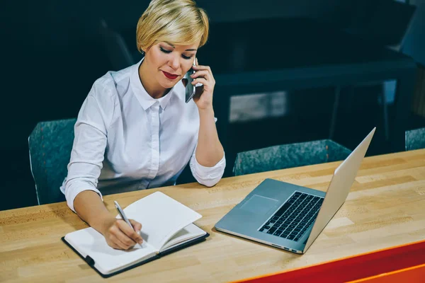 Donna Matura Che Chiama Smartphone Prende Appunti Nel Blocco Note — Foto Stock