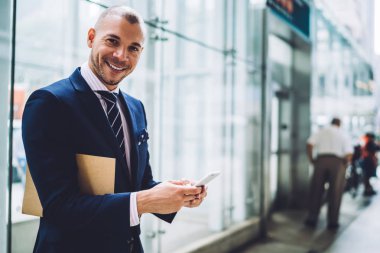 Başarılı bir iş adamı portresi modern smartphone cep telefonu ile online sohbet mesajlaşma ise kameraya gülümseyen formal giyim giymiş. Müreffeh olumlu gurur CEO'su telefonla metin bildirimi yazarak