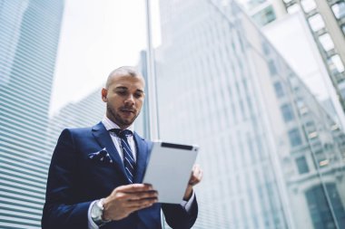 4 g kullanarak internet sitelerinde finansal haber okuma görünümünün resmi başarılı erkek tüccar altındaki giymek internet üzerinde modern tablet ayakta iş şehrin modern gökdelenler ile sokakta