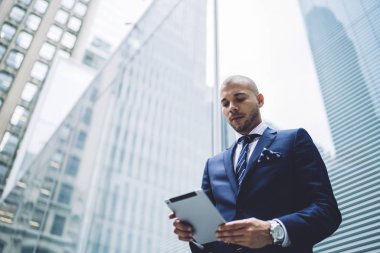 Dokunmatik holding finans şirketinin emin sahibi görünümü altında el yastık ve app ile online navigator 4 g kullanarak güncelleştirme Internet şehir merkezinde. Tablet ayakta yakınındaki yüksek gökdelenler ile işadamı