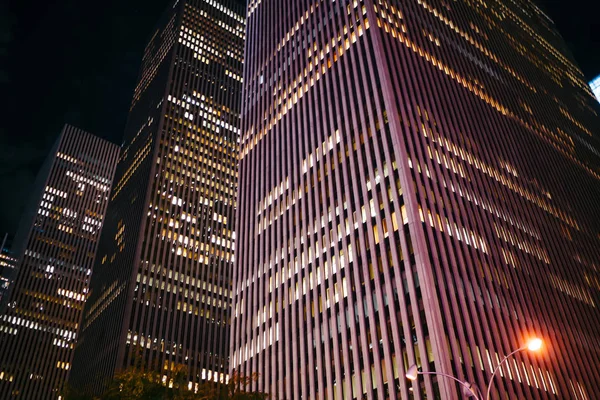 高大的摩天大楼外观与明亮的窗口办公室在商业中心的都市 现代建筑与公寓出租和公司总部在晚上位于顺风车 — 图库照片