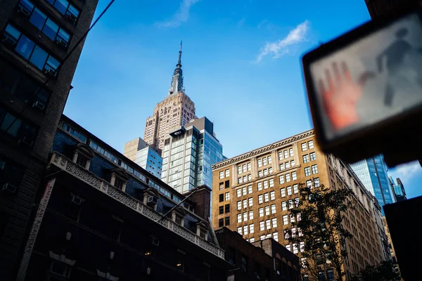 Urban setting with tall buildings in downtown and traffic light with stop sign regulating traffic, view of contemporary architecture of real estate in megalopolis for residents and business ren