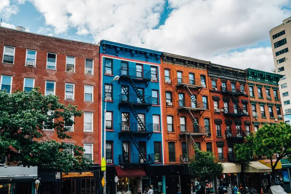 Beautiful cityscape of vintage colourful building with fire escape from residential flats and commercial real estate on ground floor,old houses in Brooklyn district with rental apartments for livin