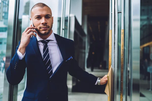 Portrait Confident Businessman Opening Door Out Office Building While Calling — Stock Photo, Image