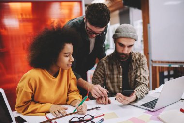 Takım çok kültürlü öğrenci üniversite işbirliği sırasında modern smartphone video blog tartışmaya formal giyim giymiş. Online eğitsel telefon izlerken çeşitli gençler