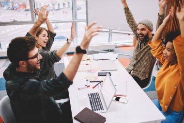 Neşeli takım rahat kıyafet çok kültürlü genç insanların office toplantıda beyin fırtınası sırasında yarışma kazandı. Proje zaferi kutluyor mutlu erkek ve kadın tasarımcılar farklı grup