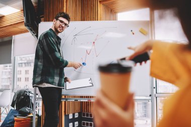 Profesyonel erkek lideri Flip grafik kullanma modern office iş Atölyesi yürütmektedir. Üniversitede ders sırasında üretken strateji açıklayan rahat kıyafet koç zeki genç adam giymiş