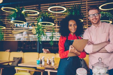Başarılı ortaklık geliştirme ortak iş deneyimli beyaz Yöneticisi ile Afrika kökenli Amerikalı profesyonel barista portresi. Kafe ve garson kameraya gülümseyen menü ile sahibi