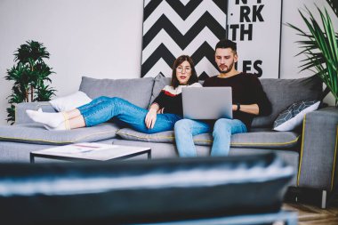 Kaç film modern bilgisayarda boş vakit birlikte dairede Kablosuz Ev Internet bağlantısı kullanarak Web sitesinde arama aşık. Evlilik rahat kanepede dizüstü cihaz ile dinlenme