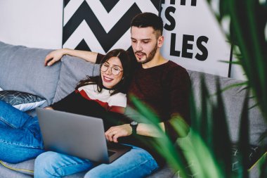 Kız ve erkek arkadaşı film seçme evde oturan kablosuz internet kullanarak dizüstü bilgisayarınızda izlemek için. Genç evlilik evinde istirahat netbook üzerinde Web sitesinde ortak seyahat için bilet rezervasyonu