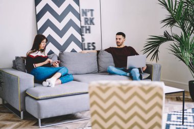 Kocası ile rahat koltukta oturan ve zekâ karısı hangi sosyal ağlar ile şık iç mekanlara modern daire ev kablosuz internet kullanarak akıllı ileti iletişim Dizüstü aygıtı