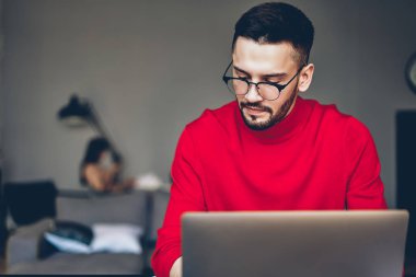 Serbest, verimli çalışması için yüksek hızlı kablosuz internet bağlantısı kullanarak modern dizüstü bilgisayar üzerinde çalışan sağlamak gözleri koruma için şık gözlük dalgın sakallı genç adam