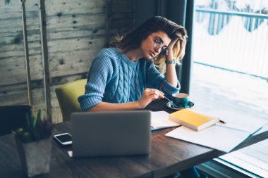 Beyaz kadın otodidakt duygu vakit sınavı için hazırlanıyor süre yorgun, Genç kadın başlangıç projesi üzerinden dizüstü bilgisayar ve kitap için araştırma yaptıktan sonra kahve molası var