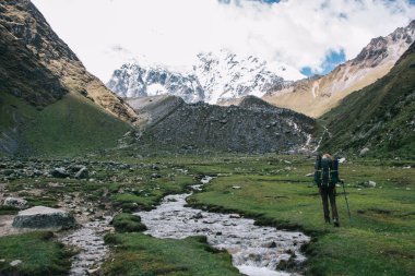 Arkadan görünüşü kadın turist Salkantay doğa yürüyüşü hiking sırasında çevre yüksek dağlarla kaplı kar keşfetmek seyahat sırt çantası ile. Peru gezisi sırasında yürüyüş sırt çantası olan kadın