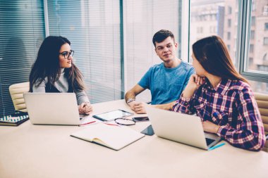 Kadın ve erkek öğrenciler sınava kapalı hazırlama tatilinde öğrenme e söz zeki bin yıllık hipsters üniversite modern sınıf, dizüstü bilgisayarda kablosuz bağlantı kullanarak