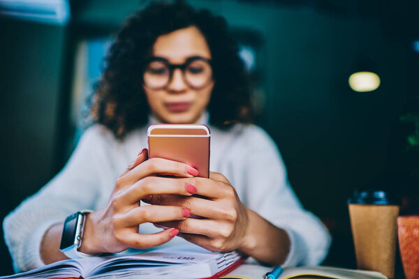 Выборочный фокус на женские руки со смартфоном, молодая женщина блоггер болтает с последователями через сотовый телефон, подключенный к интернету 4G, хипстер девушка набирает номер с помощью мобильного телефона в университетском городке
