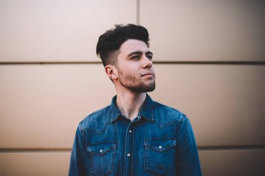 Genç yakışıklı sakallı adam düşünceli uzakta duvar arka planda, gelecek için büyük fikirler hakkında düşünme açık havada giymiş rahat kıyafet poz teen hipster adam ayakta kot gömlek arıyor