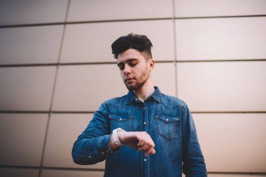 Rahat kıyafet modern smartwatch yönetmek zaman ve okuma bildirim, düşünceli erkek hipster dijital kol saati ve düzenlemek için apps ile yeni mesaj kontrol bakarak ciddi yakışıklı adam