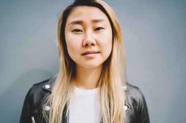 Yarım uzunluk portre ciddi Asyalı kadın çekici genç promosyon arka plan yakın vakit rahat kıyafetler giymiş. Güzel kadın, açık cilt yüz ve hiçbir yapmak görünümünü kapat