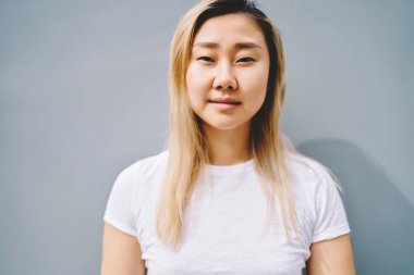 Pretty Asya kadın kişi kopya alanı ile duvara reklam içerik için ayakta kırpılmış görüntü. Yarım uzunluk portre sevimli hippi kız açık havada vakit ise kameraya bakıyor