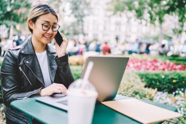 Blogger iletişim süre downloading için smartphone uygulama kullanarak daha iyi görüş için bardaklarda şehir parkında oturan dizüstü bilgisayarda ağ üzerinden dosyaları iyi başarılı Asyalı kadın arıyorum