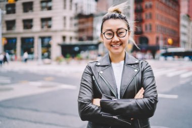 Büyüleyici duygusal hipster kız rekreasyon kentsel ayarda yürürken tadını gözlükler yarım uzunluk portre. İçtenlikle kameraya açık havada bakarken gülüyor sevimli neşeli kadın