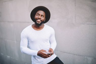 Genç kopya alanı ile beyaz gömlekli adam koyu tenli yenilikçi markası veya sokakta duran, Afro-Amerikan popüler adam cep telefonu açık havada kullanarak arayan gülümseyen etiket için olumlu