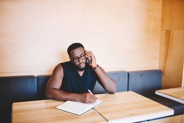 Koncentrerad Afrikanska Amerikansk Affärsman Att Göra Noterar Telefon Rådgivning Med — Stockfoto