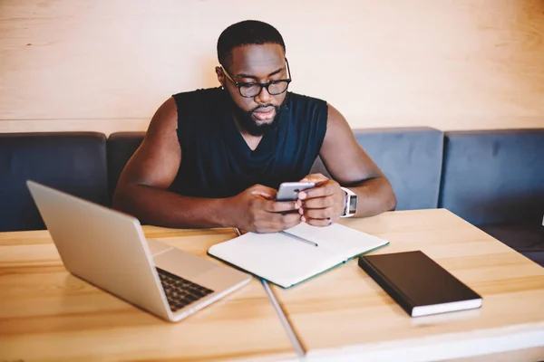 Allvarlig Afroamerikanska Hipster Killen Glasögonen Kontrollera Anmälan Smartphone Medan Lärande — Stockfoto