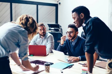 Ofis iç toplantı sırasında yeni strateji planlaması üzerinde birlikte çalışan genç gururlu CEO uzmanlarından oluşan yaratıcı ekip, beyin fırtınası brifingi ve işbirliği sırasında fikirleri tartışan bir grup çalışan