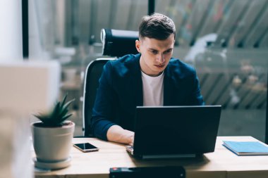 Ofis iç çalışırken iş için yeni çalışanlar kiralamak için içerik web sitelerinde bilgi arama ciddi çalışan, netbook üzerinden önemli web semineri izlerken resmi giyim konsantre adam