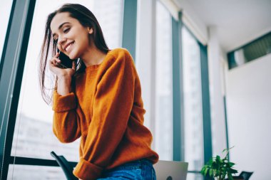 Oldukça beyaz çalışan 4g internet kapalı bağlı arkadaşı ile bilgi tartışmak için akıllı telefon gadget kullanarak, mutlu neşeli hipster kız uygulama üzerinden mobil konuşma yapma