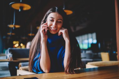 Neşeli genç kız öğrenci 4g bağlantısı ile cep telefonu danışın, başarılı bir kadın gülümseyerek arama uygulama ve modern akıllı telefon kullanarak üniversite kampüsünde boş zaman zevk yapma