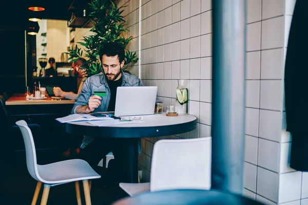 Allvarlig Hipster Guy Holding Kreditkort Kontrollinformation För Att Göra Transaktionen — Stockfoto