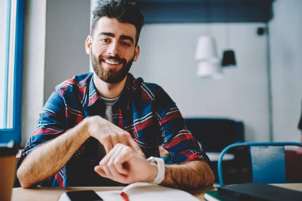 Retrato Joven Barbudo Positivo Sonriendo Cámara Mientras Señala Pantalla Reloj — Foto de Stock