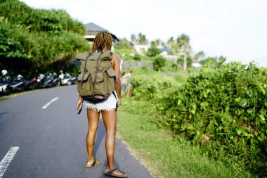 Tropik adada yaz macerası sırasında yeni doğa ortamı keşfetmek sırt çantası ile afro Amerikalı kadın turist Geri görünümü, sırt çantası açık havada gezinen koyu tenli aktif kadın