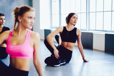 Sağlıklı merkezde vücut içi planlama egzersizi yapan mutlu fitness kadını, pilates yapan zayıf kızlar spor salonunda egzersiz yapıyor, sağlıklı yaşam tarzı motivasyonu ve spor stüdyosu konsepti.