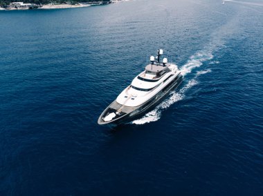Aerial view of luxury yacht goes to open sea with beautiful blue colour of water. Wealth recreation lifestyle. Bird's eye view of expensive floating ship traveling by Europe in summer clipart